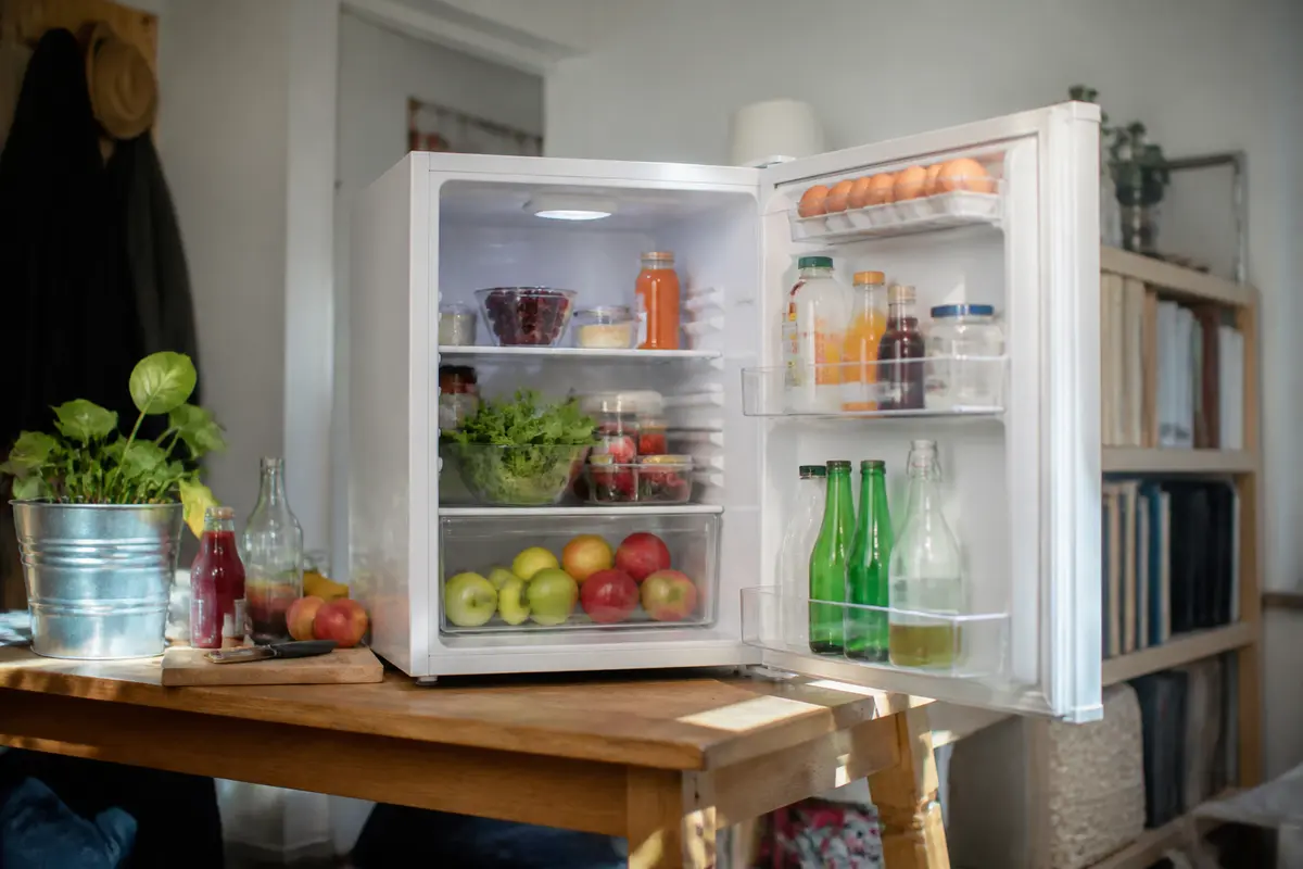 Frigo Liebherr en haut de table rempli de fruits, légumes et boissons diverses