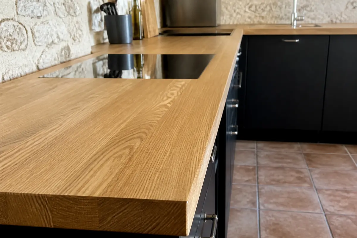 Cuisine moderne avec plan de travail en frêne, plaque de cuisson intégrée.