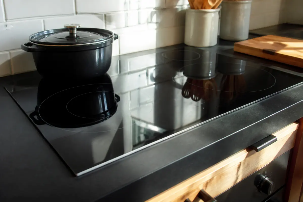Casserole sur plaque vitrocéramique Bosch intégrée dans une cuisine moderne et lumineuse
